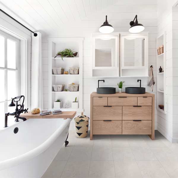 modern farmhouse bathroom with stone look tile floors and wooden vanity